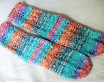 May include: A pair of colorful striped socks in shades of blue, orange, purple, and white. The socks are made of a soft, knitted fabric.
