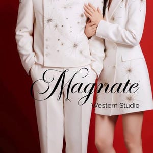 May include: A couple in matching white outfits with starburst embellishments, posing against a red backdrop. The man wears a suit, and the woman wears a blazer and skirt. The text "Magnate Western Studio" is visible.