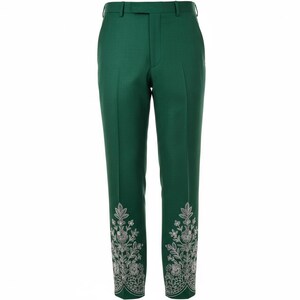 May include: Emerald green tailored trousers with silver floral embroidery on the hem. The trousers have a classic design with a belt loop and button closure. The trousers are approximately 100 cm in length.