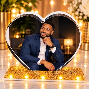 May include: A large heart-shaped frame with a reflective silver border and a base covered in shimmering gold sequins. The base features five integrated warm white light bulbs that illuminate the front, creating a bright and decorative display piece.