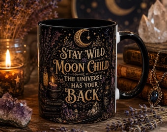 May include: A black ceramic mug featuring a gold crescent moon and the text Stay Wild Moon Child The Universe Has Your Back. The design includes illustrations of candles, crystals, books, and lavender sprigs in a dark, celestial-themed style.