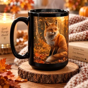 Peut inclure: Une tasse en céramique noire avec une image imprimée d'un renard roux assis dans une forêt avec des feuilles d'automne. La tasse a une finition brillante et une anse incurvée, présentant une scène animalière détaillée aux tons orange et brun.