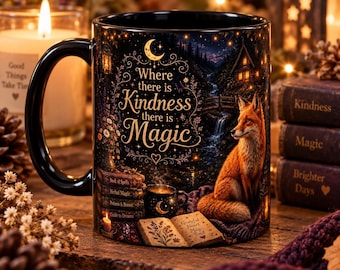 May include: A black ceramic mug featuring a fox sitting near a stream and a cabin. The text reads Where there is Kindness there is Magic. The design includes a stack of books titled Book of Spells, Herbal Magic, Potions & Brews, and Guide to Dreams.