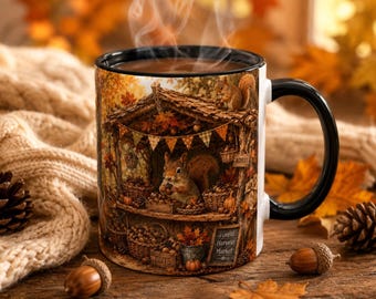 May include: A ceramic mug with a black handle and rim, featuring a detailed illustration of a squirrel at a forest harvest market stall. The scene includes baskets of nuts, pumpkins, and autumn leaves, with a sign reading Forest Harvest Market.