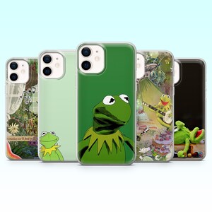 May include: A selection of phone cases featuring Kermit the Frog. The cases showcase different images of the character, including a close-up of his face, and scenes with musical instruments. The cases are in clear protective covers.