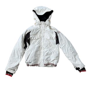 May include: A white hooded jacket featuring black accents on the shoulders and chest, two front flap pockets, and a front zipper closure. The cuffs have inner black fabric with red and white stripes, and the word Section is printed on the lower front.