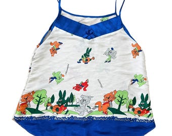 Camiseta sin mangas azul con estampado animal de dibujos animados kitsch de los 90 con ribete de satén y pequeña nota musical