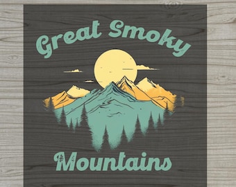 May include: A square DTF transfer sheet featuring a graphic of the Great Smoky Mountains with a large yellow sun, teal mountain peaks, and dark green pine trees. The text reads Great Smoky Mountains in a curved teal font on a dark background.