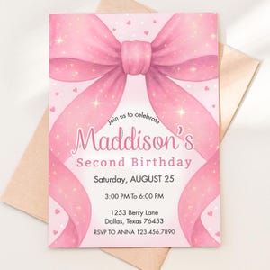 Pode incluir: Um convite de aniversário rosa com um grande laço. O convite diz "Segundo Aniversário de Maddison" com detalhes do evento, incluindo a data, hora e local em Dallas, Texas. O convite está em um fundo branco com pequenos corações.