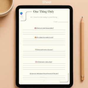 May include: A digital tablet displaying a printable daily focus sheet titled "One Thing Only." The sheet includes prompts for daily focus, importance, obstacles, and feelings. A pencil and a cup of coffee are next to the tablet.