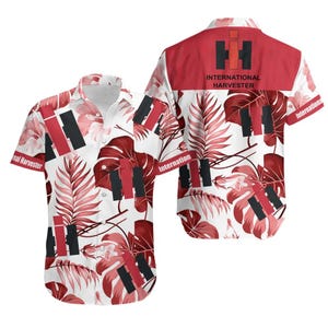 Puede incluir: Camisa de manga corta con fondo blanco adornada con formas geométricas rojas y negras y patrones de hojas rojas. La camisa muestra las palabras "International Harvester" en la espalda y las mangas.