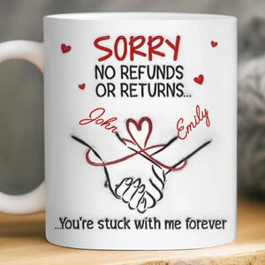 May include: White ceramic mug with the text "SORRY NO REFUNDS OR RETURNS..." in red. The mug features a graphic of two hands holding each other, with the names "John" and "Emily" and a heart design. The bottom of the mug reads "...You're stuck with me forever."