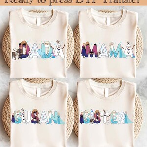 Könnte beinhalten: Vier cremefarbene T-Shirts mit den Wörtern DADA, MAMA, SUSAN und SISTER in einer farbenfrohen, cartoonartigen Schriftart. Die Buchstaben sind mit Figuren aus einem beliebten Animationsfilm verziert. Der Text "Ready to press DTF Transfer" steht oben.