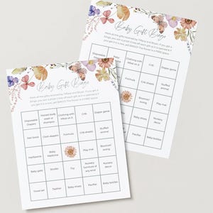 May include: Two baby gift bingo cards with floral and butterfly illustrations. The cards have a grid layout with various baby-related terms. The text "Baby Gift Bingo" is at the top, with instructions below.
