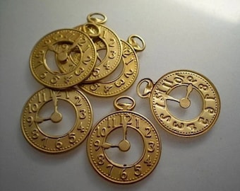 May include: Six gold-coloured metal clock face charms with Roman numeral markings and a single hand. The charms have a hole at the top for hanging.