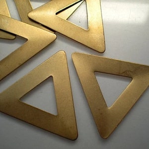 May include: Five gold-coloured metal triangle shapes with a hole in the centre of each triangle.