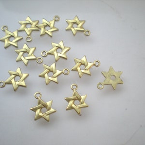 May include: A collection of gold-toned metal charms shaped like a six-pointed star, also known as the Star of David. Each charm has a small loop at the top for attaching to jewelry or other crafts.