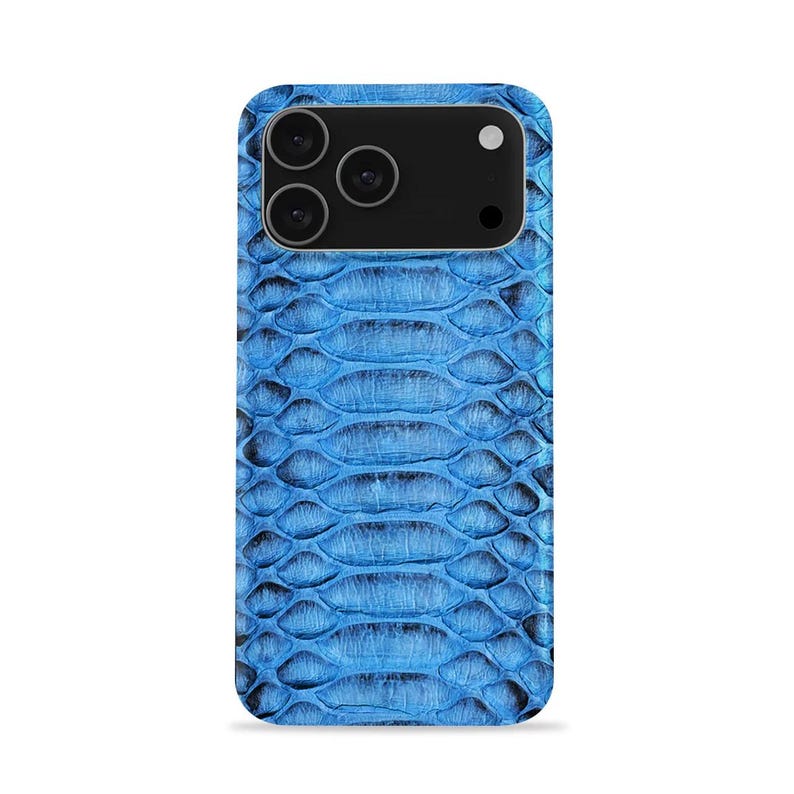 May include: A blue smartphone case featuring a snakeskin design. The case has a black camera module with three lenses and a flash. The case is designed to fit a smartphone and offers protection with a stylish appearance.