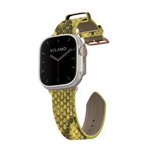 May include: A silver smartwatch with a black screen and the word "VELANO" displayed. The watch features a yellow and green snakeskin-patterned band with a brown underside. The band is attached with rose gold hardware.