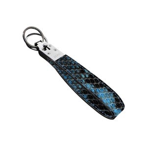 May include: A blue and black snakeskin-patterned keychain wrist strap with a silver-tone metal clasp and ring. The strap is made of a textured material and features the word "VELANO" on the metal hardware.
