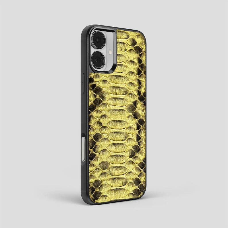Peut inclure: Une coque de smartphone noire avec un motif de peau de serpent dor&eacute;. L'&eacute;tui a une finition brillante et un bord noir. L'&eacute;tui de t&eacute;l&eacute;phone poss&egrave;de un appareil photo &agrave; double objectif et un flash.