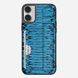 Op de afbeelding: Een blauwe telefoonhoes met een textuurpatroon dat op slangenleer lijkt. De hoes heeft een zwarte rand en een gleuf voor een creditcard. Op de creditcard staat "AMERICAN EXPRESS".
