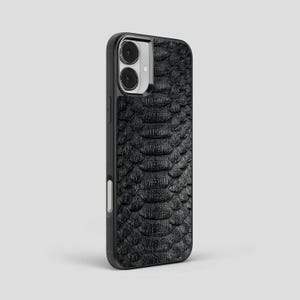 May include: A white ceramic mug with a black handle and the text "But First, Coffee" in a bold, black font. The mug is set against a blurred background, suggesting a cosy setting.