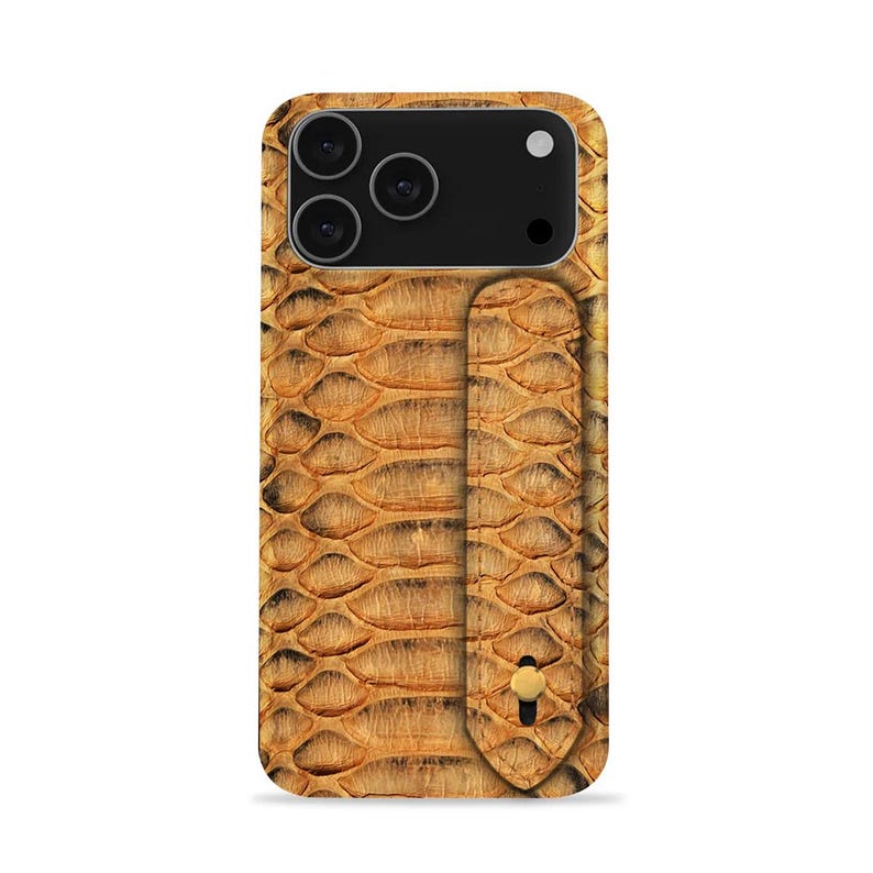 May include: A tan and brown phone case with a snakeskin pattern. The case has a vertical strap with a gold-coloured button and a black camera module with three lenses.