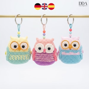 Peut inclure: Trois porte-clés hiboux crochetés à la main, aux couleurs pastel, suspendus à une barre dorée. Les hiboux ont de grands yeux et sont de couleur jaune, rose et bleu. Chaque porte-clés a un accent de perles et un anneau argenté.