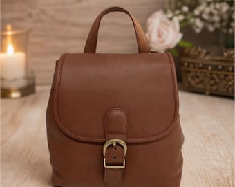 Mini mochila vintage de cuero curtido con guantes.
