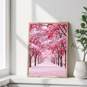 以下が含まれることがあります： 雪に覆われた桜並木のフレーム入りプリント。木々はピンクと赤の葉を持ち、白い雪と対照的です。アートワークは明るい木製のフレームに入っており、穏やかで自然なシーンを作り出しています。