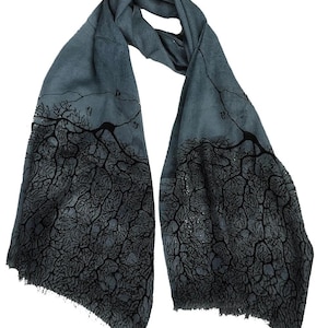 May include: A gray scarf with a black and white pattern of a tree root system. The scarf is made of a soft, lightweight fabric and is perfect for adding a touch of style to any outfit.