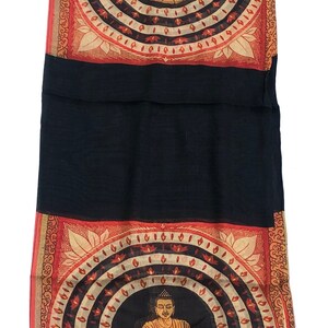 May include: Black silk scarf with a fringed edge and two printed panels. Each panel features a seated Buddha figure in a circle surrounded by a mandala design with red, orange, and white accents.
