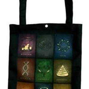 May include: Black tote bag featuring nine colorful squares with various designs. The squares include images of a cat, a brain, a wreath, a DNA strand, a dragon, a pyramid, and other symbols. The bag has two black handles and a button closure.