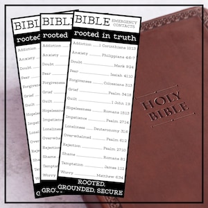 May include: Three bookmarks with the text "BIBLE EMERGENCY CONTACTS" and a list of emotions and corresponding Bible verses. A brown leather-bound Holy Bible is visible in the background.