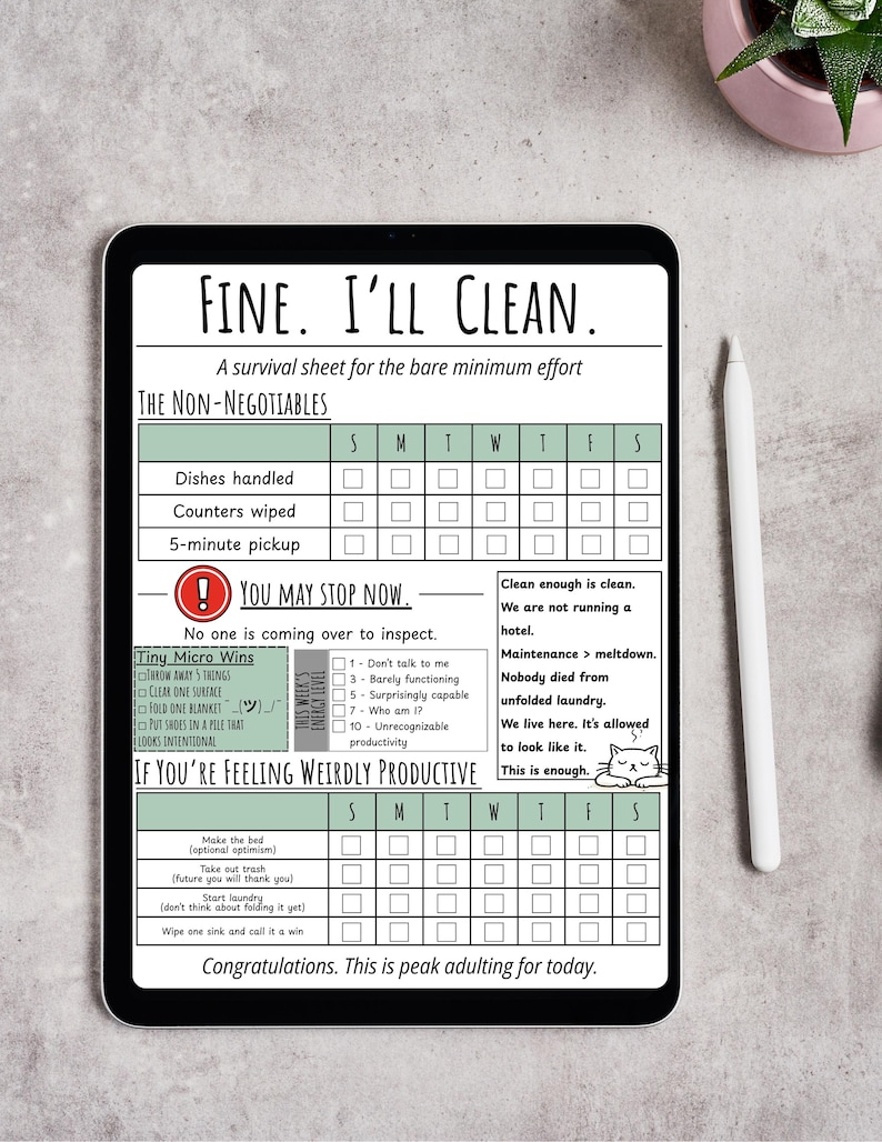 May include: A digital tablet displays a humorous cleaning checklist titled "FINE. I'LL CLEAN." The sheet includes sections for daily tasks like dishes and counters, and a section for "Tiny Micro Wins." A white stylus and a small plant are visible.