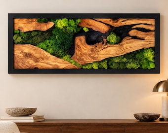 May include: A rectangular wall art piece featuring a black frame enclosing a composition of natural light brown wood segments with prominent grain patterns and deep black charred sections, interspersed with vibrant green preserved moss.