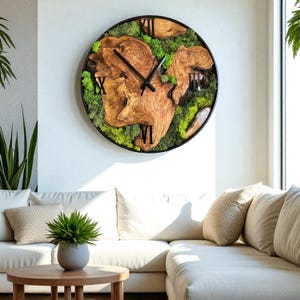 Live edge olive wood wall clock with real green moss, hanging on a rustic white wall.