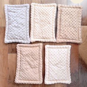 Puede incluir: Cinco alfombrillas rectangulares con una superficie texturizada de puntos, dispuestas en una cuadr&iacute;cula. Las alfombrillas son de tonos blanco, crema y bronceado claro. Cada una tiene un borde cosido. El texto en la imagen dice: Fleece Side, Pumpkin Grenade y Handmade item - size may vary slightly.