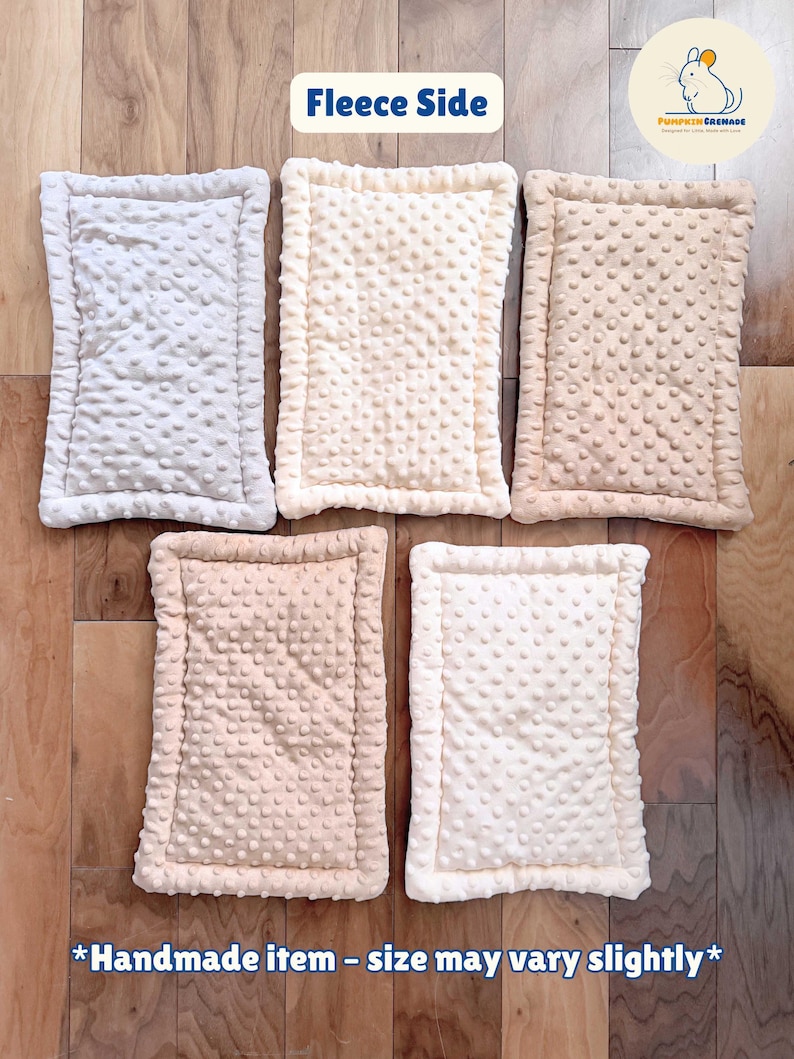 Puede incluir: Cinco alfombrillas rectangulares con una superficie texturizada de puntos, dispuestas en una cuadr&iacute;cula. Las alfombrillas son de tonos blanco, crema y bronceado claro. Cada una tiene un borde cosido. El texto en la imagen dice: Fleece Side, Pumpkin Grenade y Handmade item - size may vary slightly.