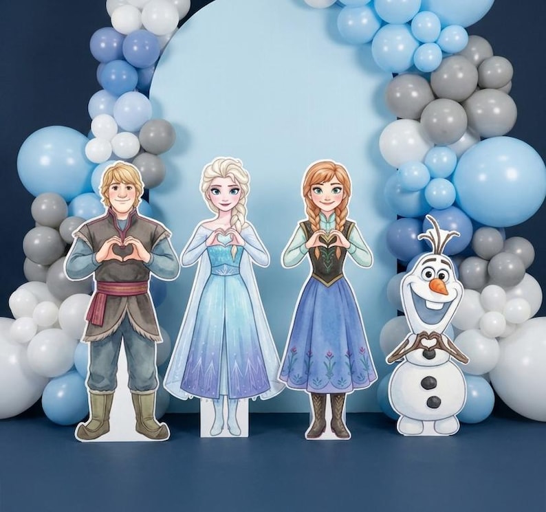 May include: Cardboard cutouts of characters from the animated film Frozen, including Kristoff, Elsa, Anna, and Olaf, are arranged in front of a blue backdrop with a balloon arch. The characters are holding their hands in a heart shape.