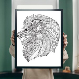 K&ouml;nnte beinhalten: Schwarz-Wei&szlig;-Kunstdruck eines L&ouml;wen in einem schwarzen Rahmen. Der L&ouml;wenkopf ist mit geometrischen Mustern aufwendig detailliert, was einen auff&auml;lligen Kontrast erzeugt. Das Kunstwerk wird von einer Person gehalten.