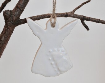 May include: White ceramic angel ornament with a textured design, hanging from a twine string.