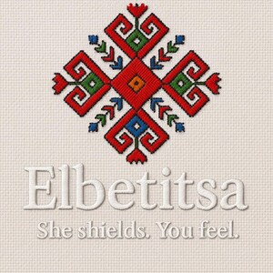Könnte beinhalten: Gesticktes Design mit einem geometrischen Muster in Rot, Grün, Blau und Orange. Das Design befindet sich über dem Wort "Elbetitsa" und dem Satz "She shields. You feel."