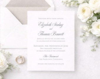 Op de afbeelding: Een witte huwelijksuitnodiging met elegant schrift, met de namen Elizabeth Sterling en Thomas Bennett. De uitnodiging bevat de datum, tijd en locatie van de ceremonie, samen met een envelop en bloemaccenten.