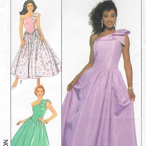 May include: Simplicity sewing pattern 9082, size 16. The envelope features illustrations of three one-shoulder dresses: a floral print dress, a solid green midi dress, and a solid lavender floor-length gown, each with a bow detail on the shoulder.