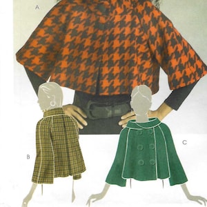以下が含まれることがあります： McCall's M5479のソーイングパターン。3種類のケープのデザイン。メイン画像は、オレンジと黒の千鳥格子のケープを着た女性です。他のオプションには、チェック柄のケープとグリーンのケープが含まれます。