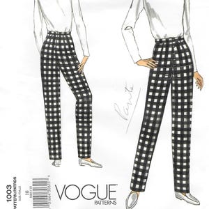 May include: Vogue Patterns sewing pattern featuring a woman in a white turtleneck and black and white checkered pants. The pattern number is 1003, with size 10. The Vogue logo is visible.