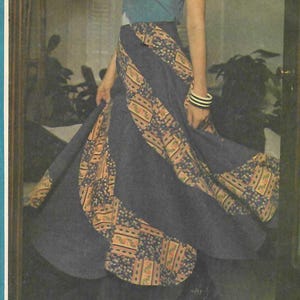 May include: McCall's 3926 sewing pattern for a skirt and top. The pattern features a woman wearing a blue top with a floral design and a long, flowing skirt with patterned panels. The text "The Swirler" is visible.