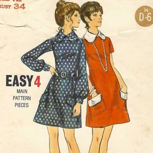 May include: A Butterick 5913 sewing pattern envelope featuring illustrations of two dresses. One is a blue long-sleeved dress with a repeating pattern and belt, the other is a short-sleeved orange dress with a white collar and pockets. Text includes Size 12, Bust 34, and Easy 4.